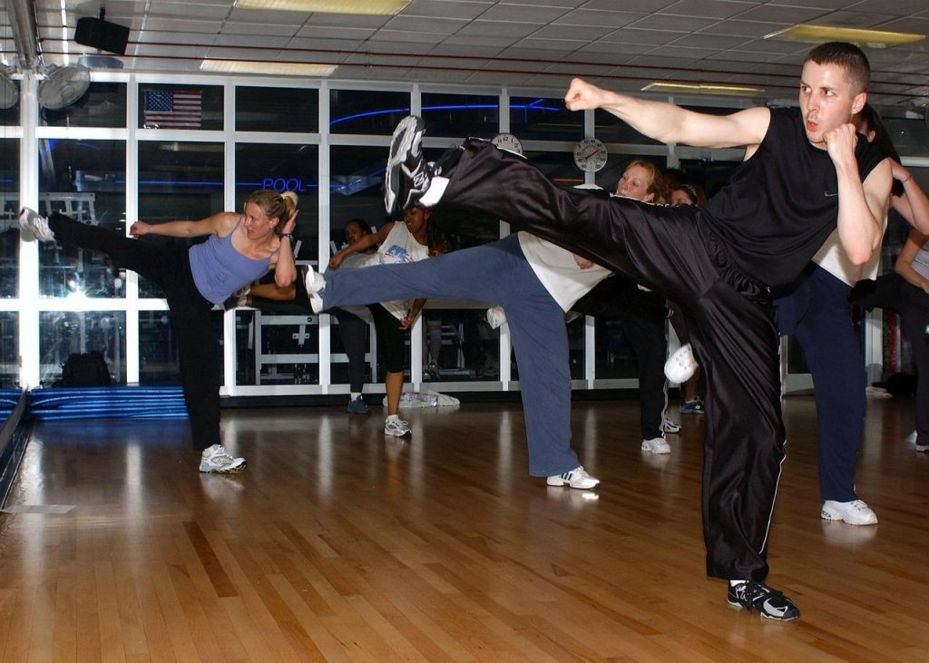 Werknemers voeren energieke kickboksen sessie uit op kantoor voor teambuilding en fitness